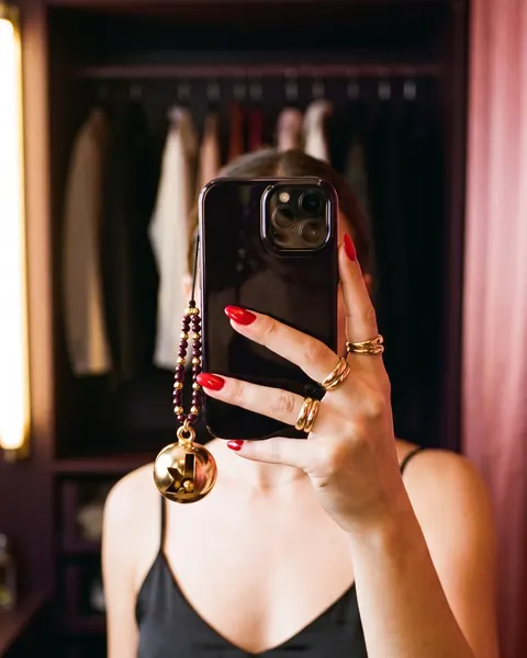A mirror selfie with the gold bell phone charm.