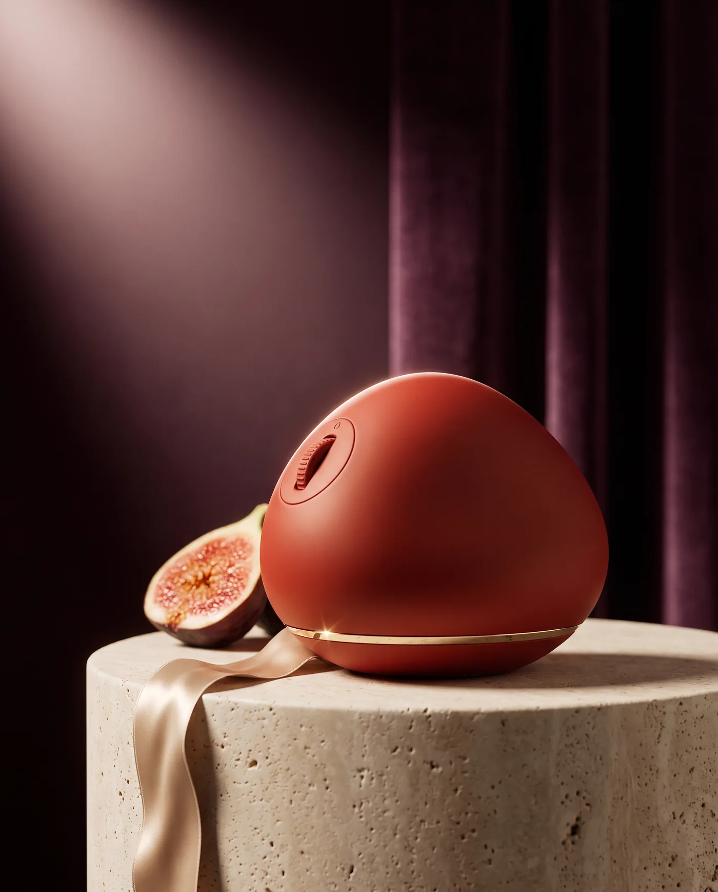 An ember-red pebble-shaped object on a travertine plinth against a plum velvet curtain, a halved fig and a silk ribbon beside it.